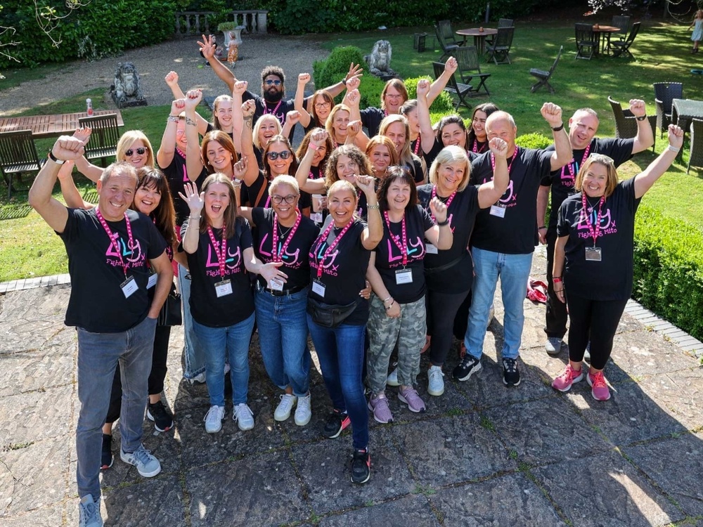 A group of Lily volunteers standing outside smiling and punching the air