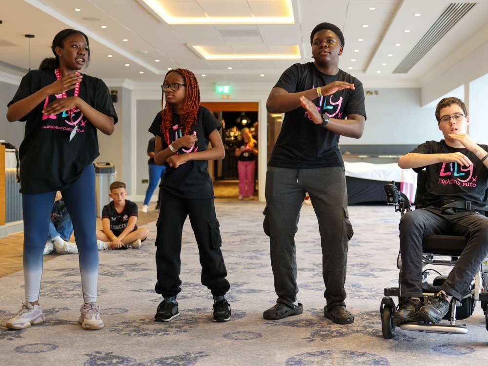 Four people dancing at the Lily weekend, one is in a wheelchair