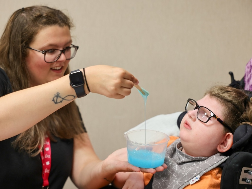 A mum helps her disabled son to make slime at the Lily Family Weekend