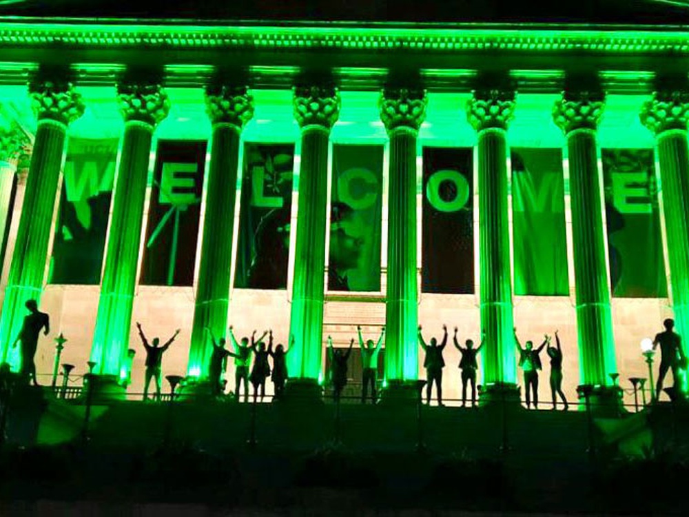 The UCL Portico building is lit up with green lights